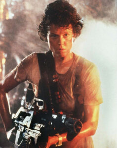 Ellen Ripley ase kädessään.